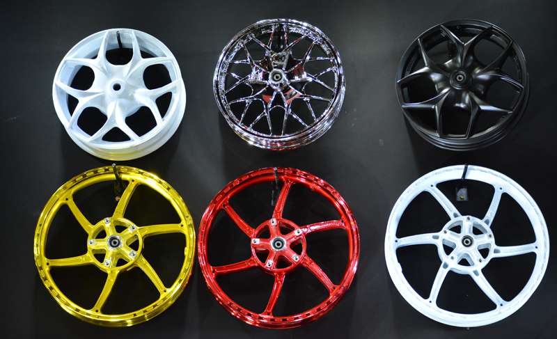 Car wheels on a dark background, painted in different colors using powder coating