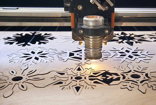 Laser cutting machine is cutting the wooden plank