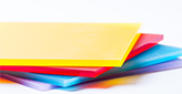 colorful polycarbonate sheets stacked on a white background