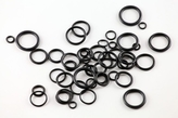 a lot of black rubber rings spread out on a white background